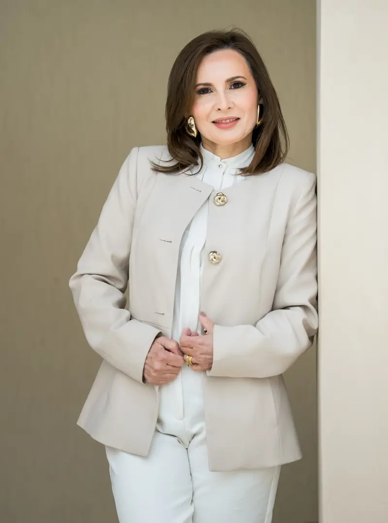 Cliente de blazer bege e camisa branca, com maquiagem natural para ensaio corporativo